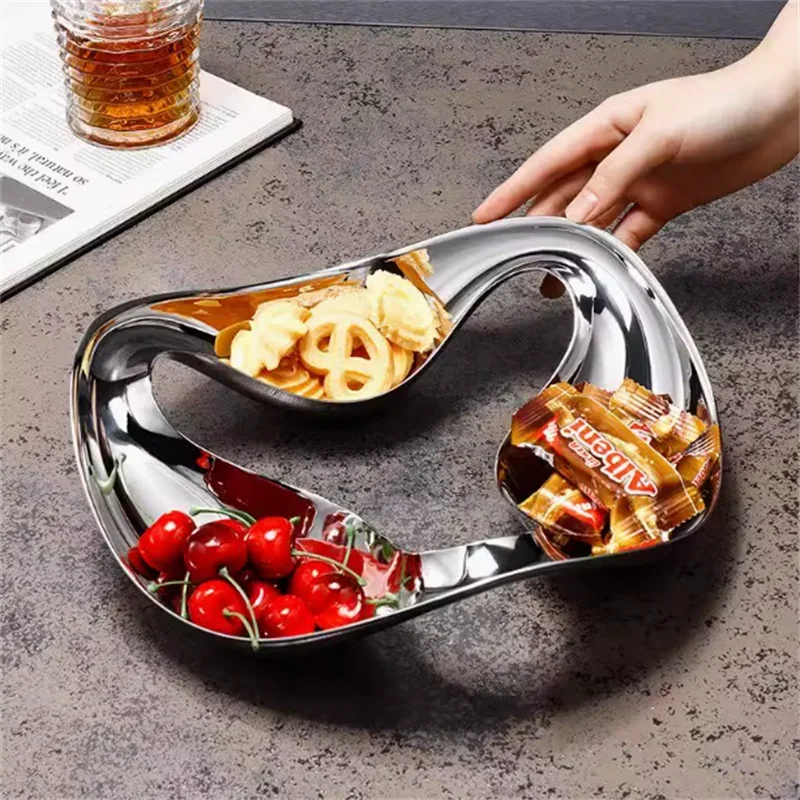 Serving dish with compartments filled with snacks on a gray surface.