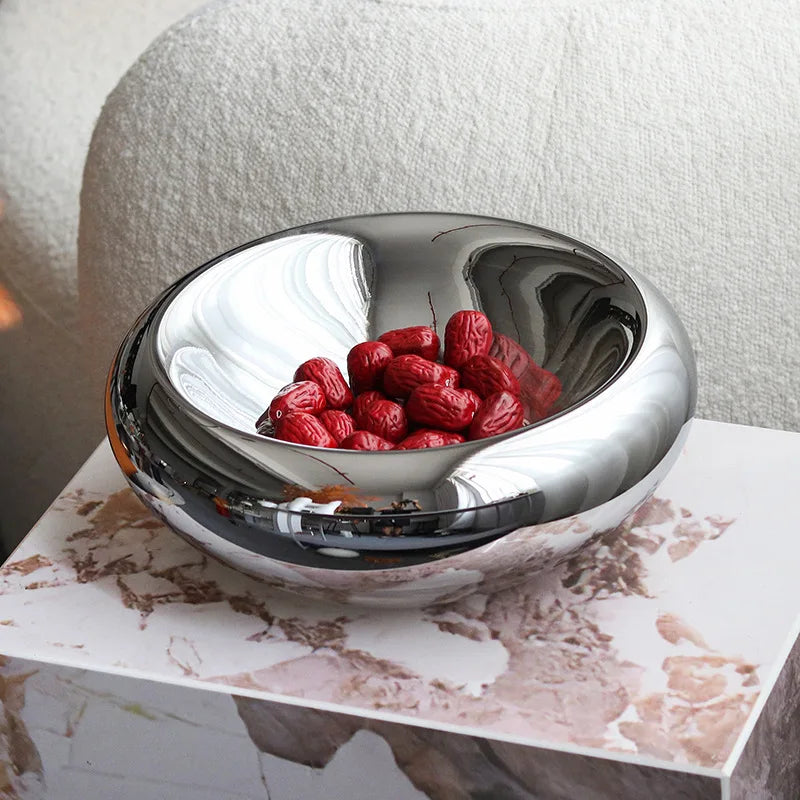 Silver bowl with red berries on a marble surface