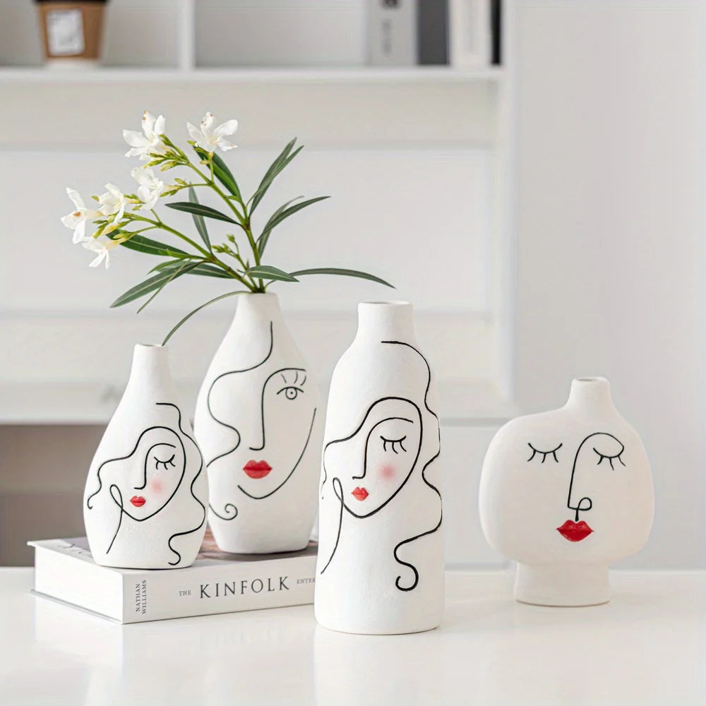 Set of white vases with face designs on a white surface