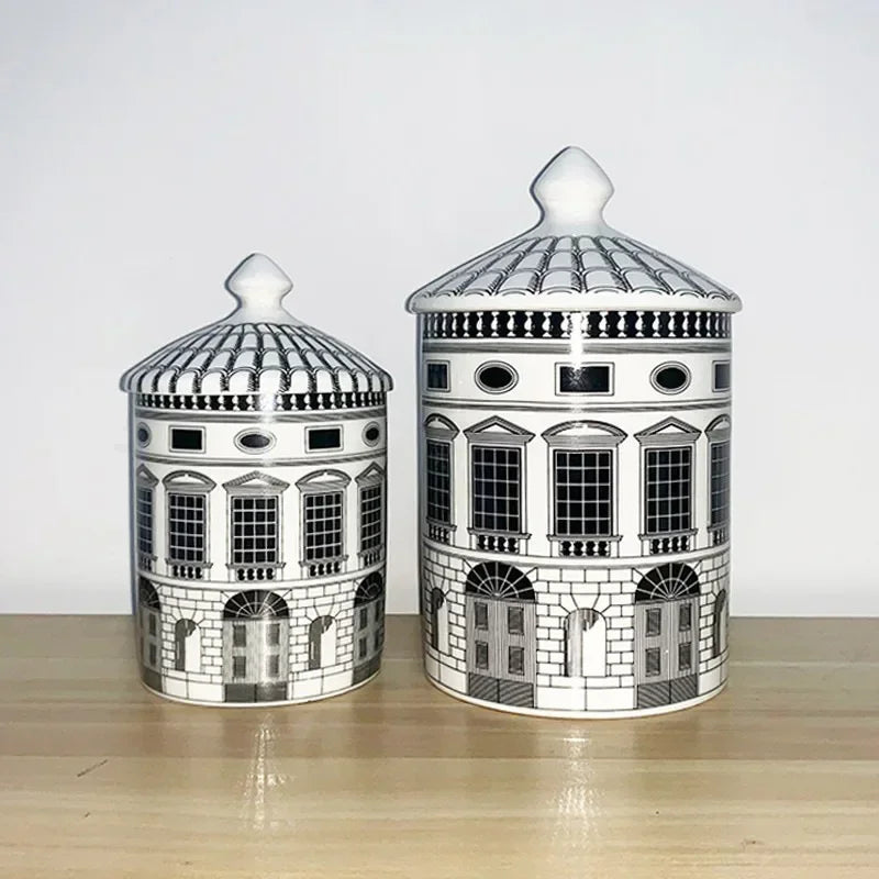Two ceramic jars with architectural designs on a wooden surface.