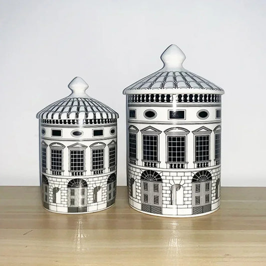 Two ceramic jars with architectural designs on a wooden surface.