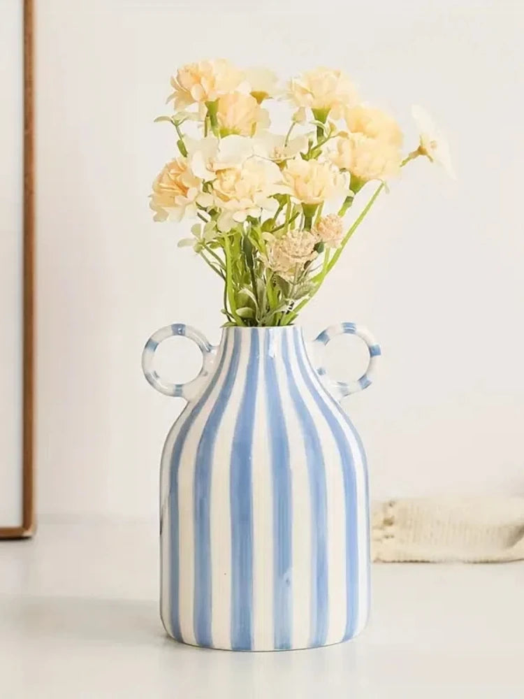 Striped vase with flowers on a light background