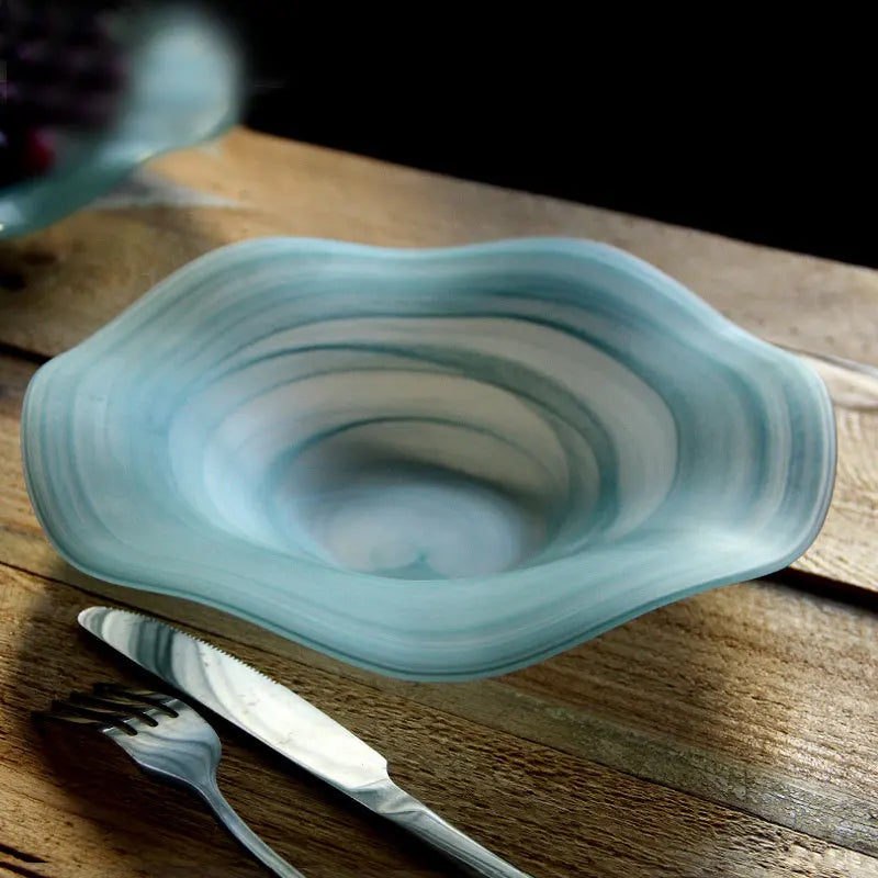 Glass bowl with swirling pattern on a wooden surface