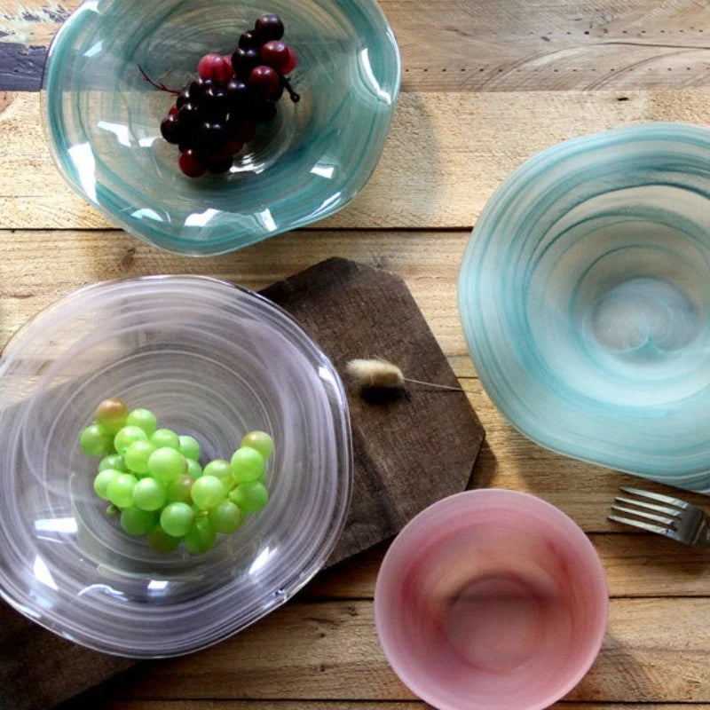 Glass bowls with fruits on a wooden surface