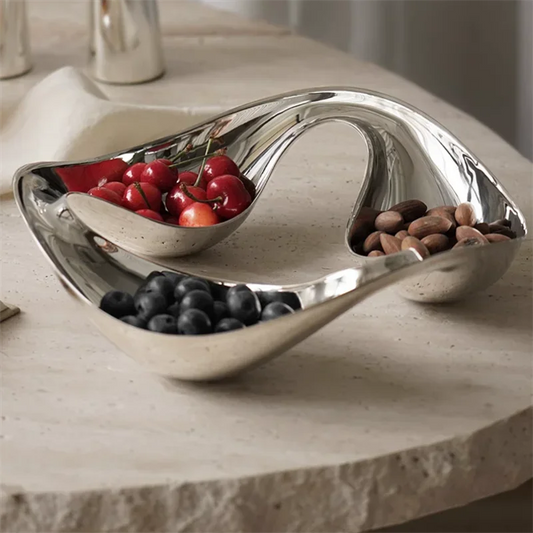 Silver wavy bowl with fruits on a stone surface