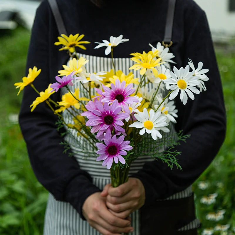 Person holding a bouquet of flowers in a garden