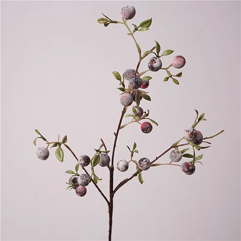 Artificial branch with green leaves on a light gray background
