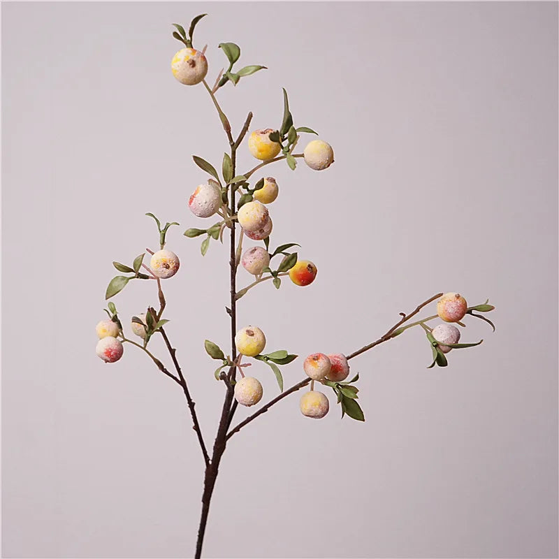 Artificial apple branch with small apples on a plain background