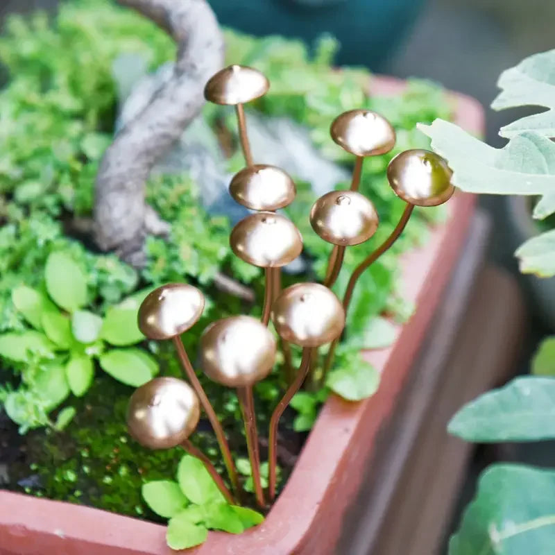 Decorative gold plant stakes in a pot with green plants