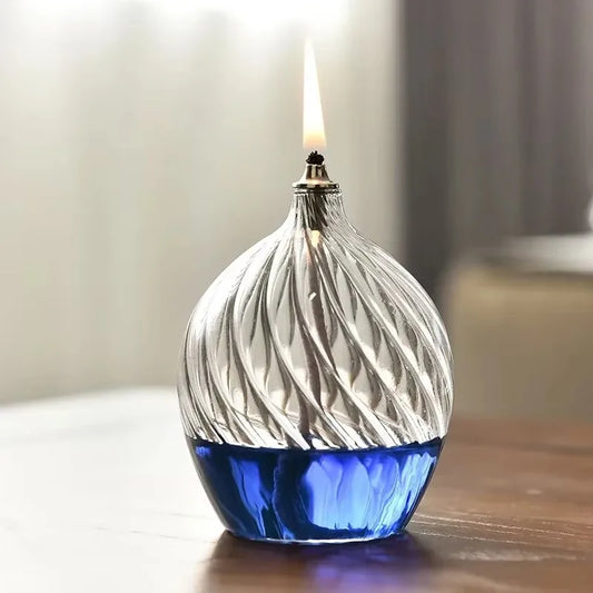Decorative glass oil lamp with blue oil and wavy design.