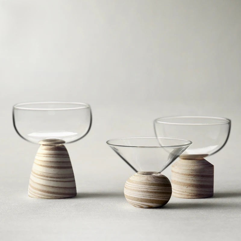 Three glass bowls with clay bases on a light gray background