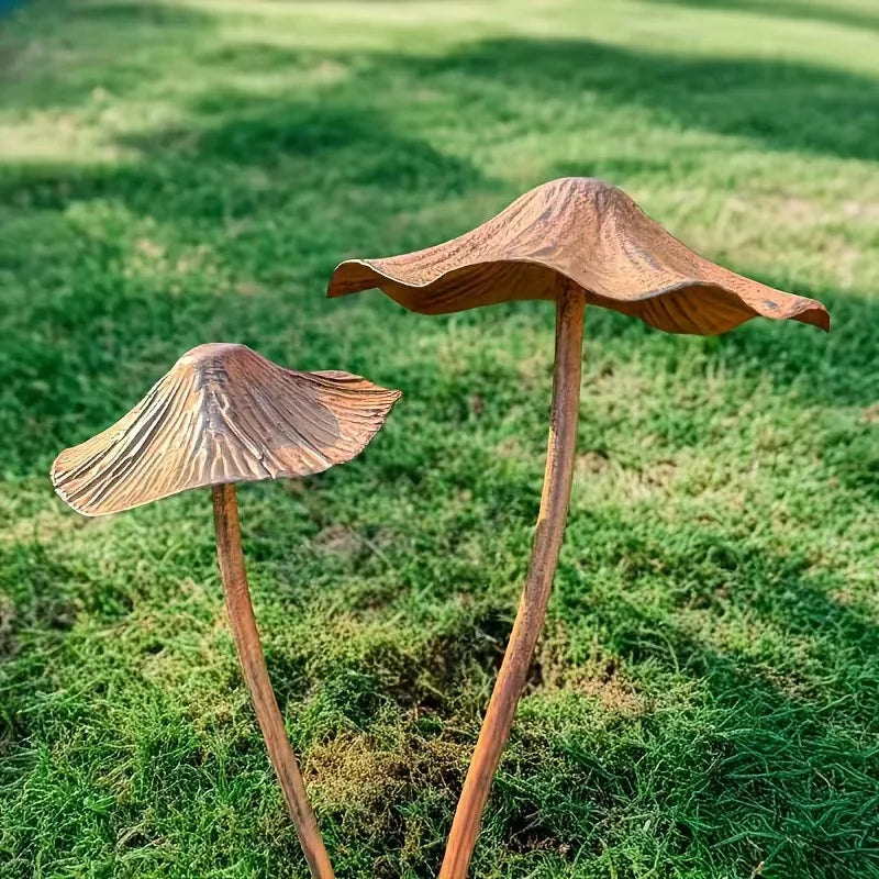 Two wooden mushroom sculptures on a grassy field