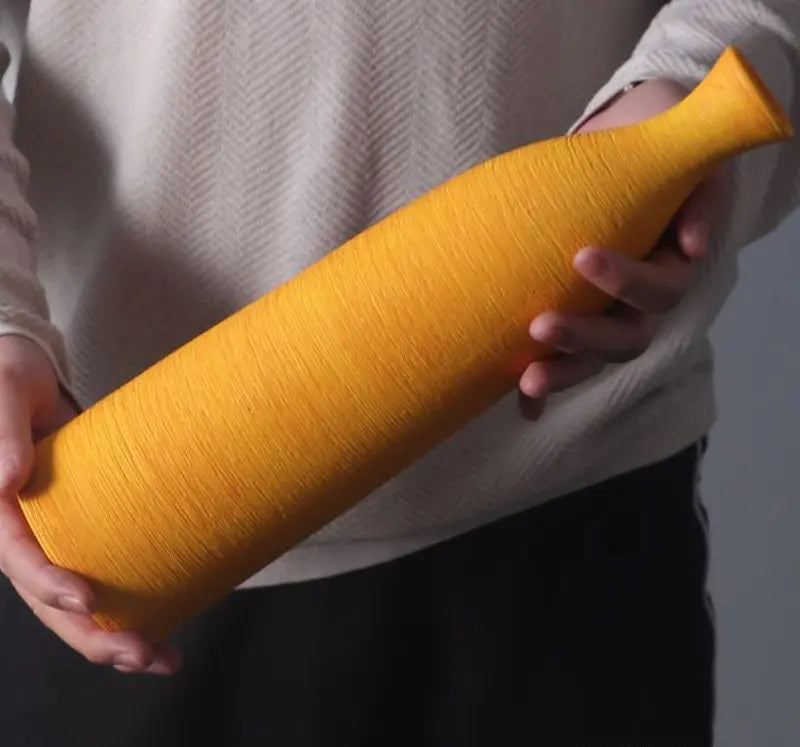 Person holding a yellow vase