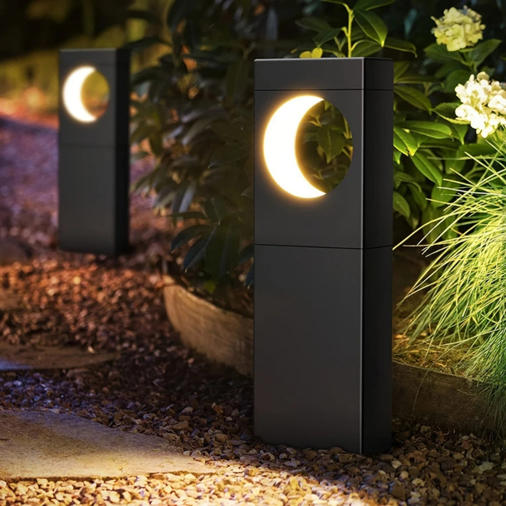 Decorative outdoor lights with moon design in a garden setting