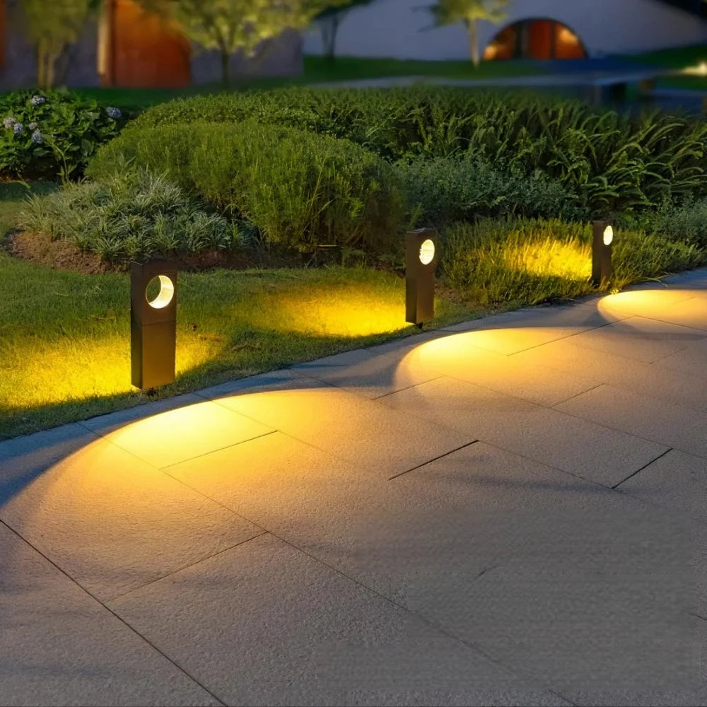 Outdoor pathway with illuminated garden lights in a well-maintained garden.