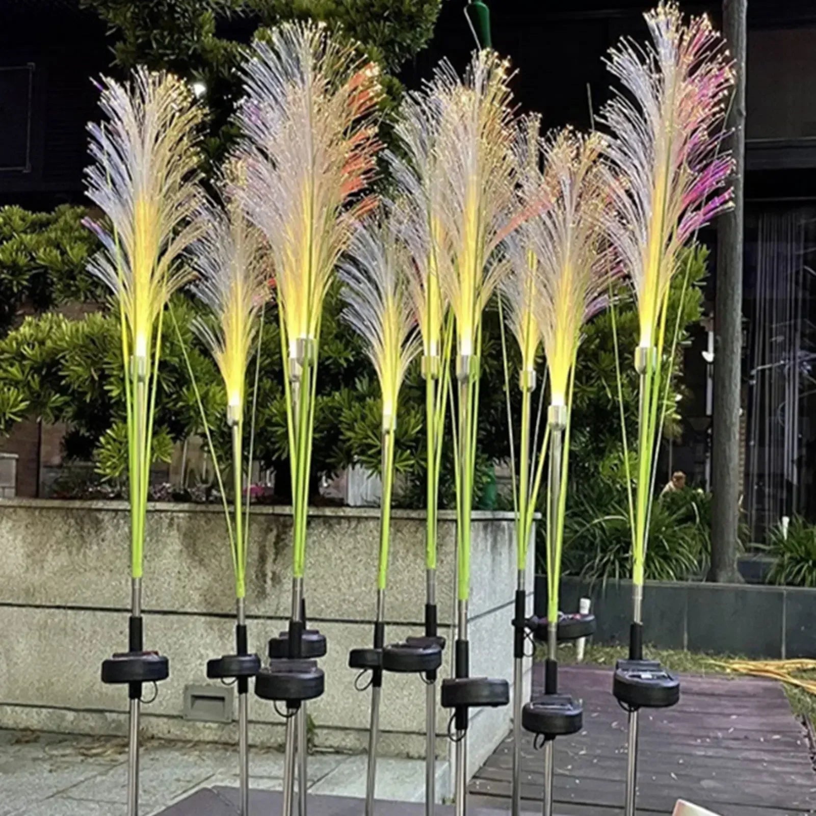 Decorative outdoor lights resembling tall grasses with a blurred background