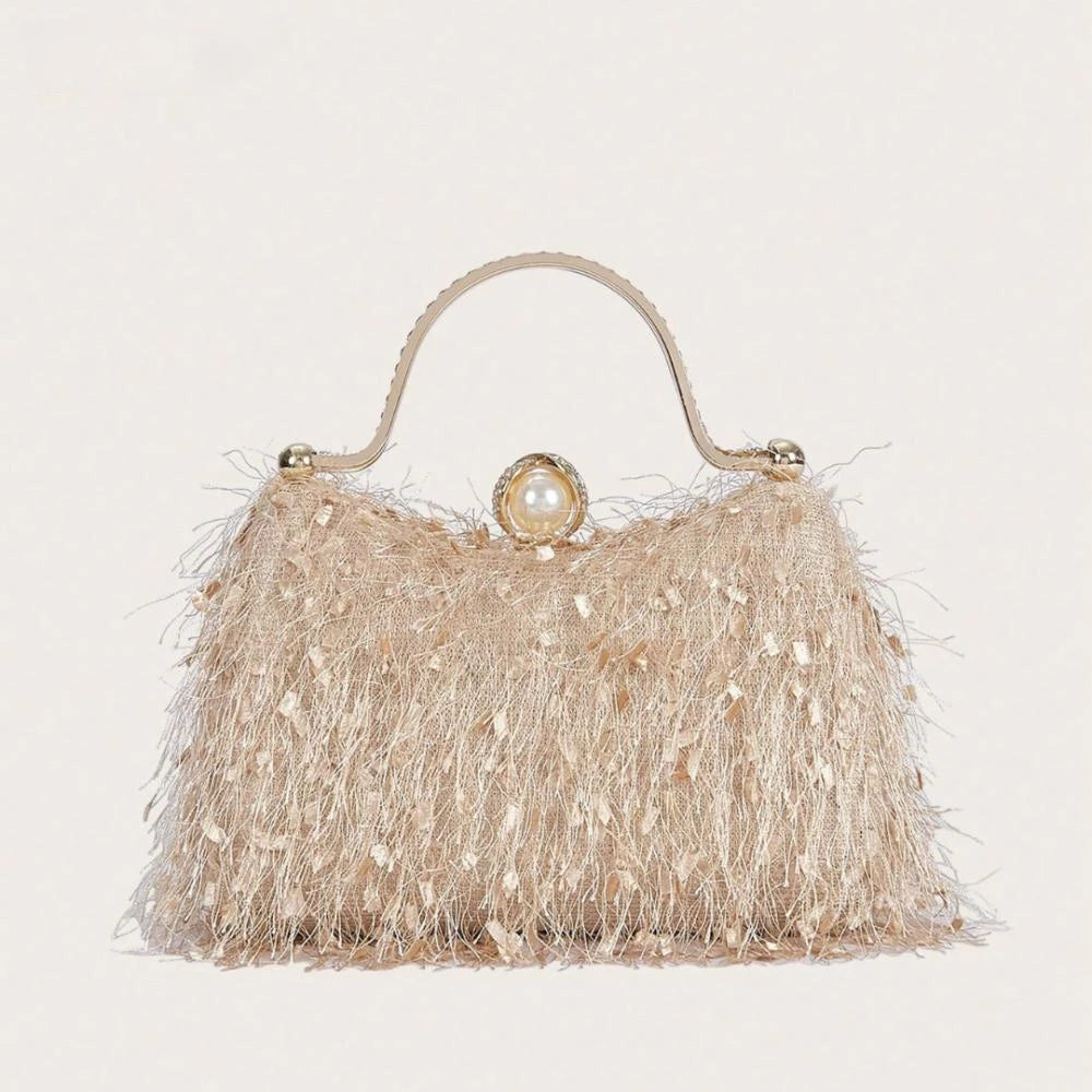 Beige handbag with fringe details and a pearl embellishment on a light gray background