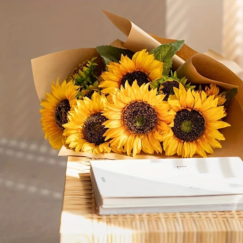 Bouquet of sunflowers wrapped in brown paper on a wooden surface with a blurred background