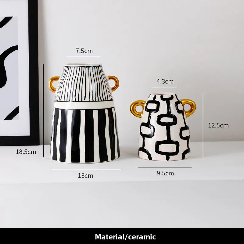 Two black and white patterned ceramic vases with gold handles, shown with dimension lines and text indicating measurements. The larger vase has vertical black stripes on a white base, and the smaller vase has a black geometric chain-link pattern on white.