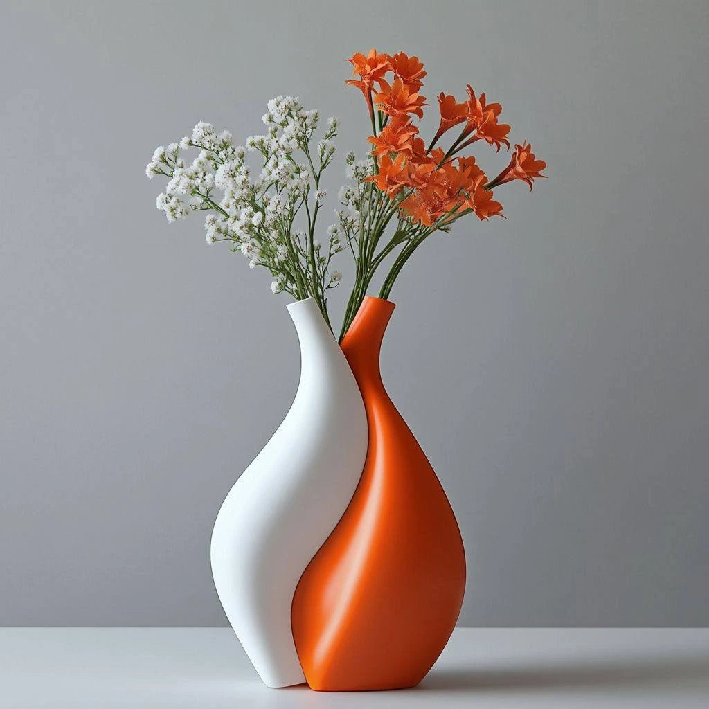 Two joined vases, one white and one orange, with flowers against a gray background